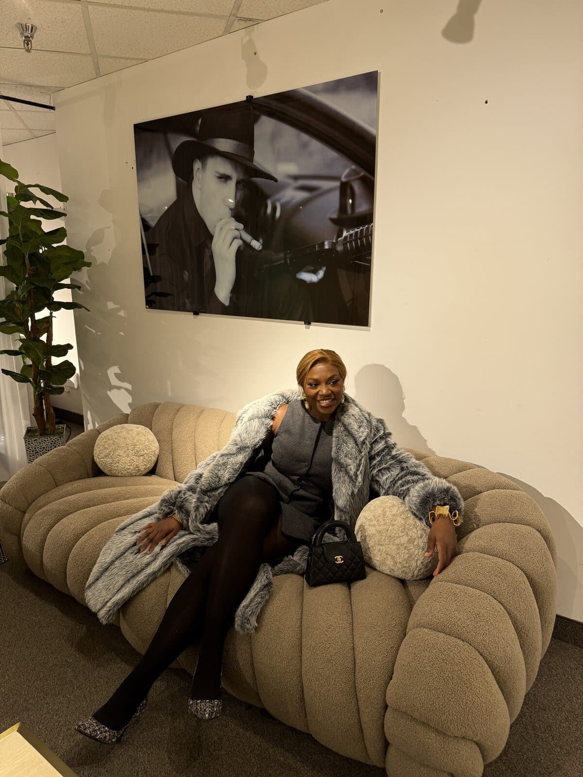 Raissa on a bouclé chair with framed art behind