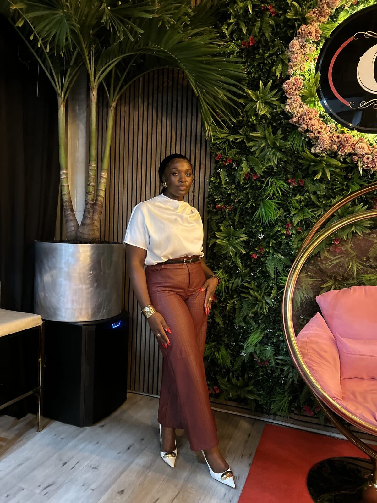 Raissa beside a botanical wall in red and white